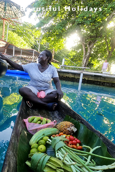 local selling vegetables from dugout canoe in the  solomon islands